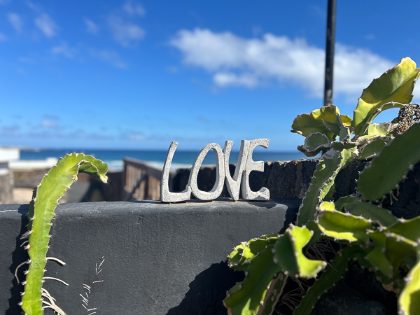 Der Schriftzug LOVE aus Stein vor blauem Himmel auf Lanzarote