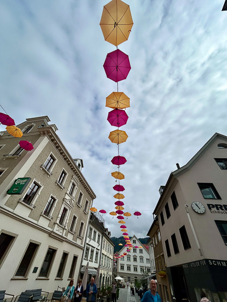 Otange udn Pinke Schirme zieren als Girlande die Fußgängerzone in Bregenz