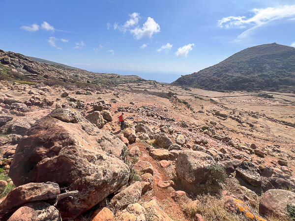 a person walking on a rocky vulcanic area