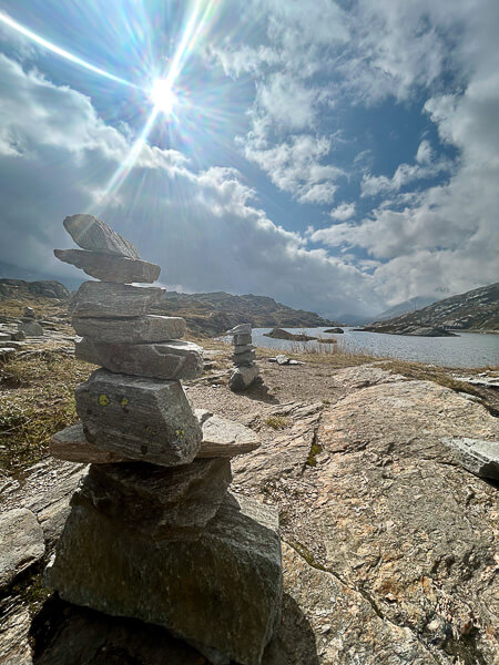 a stack of rocks on a mountain pass